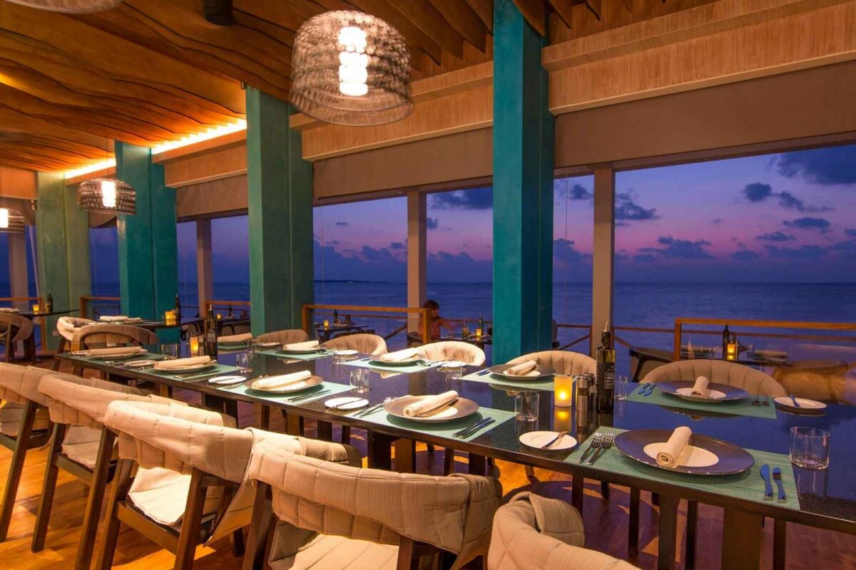 Imagen del interior de un restaurante con las luces encendidas y vistas al mar