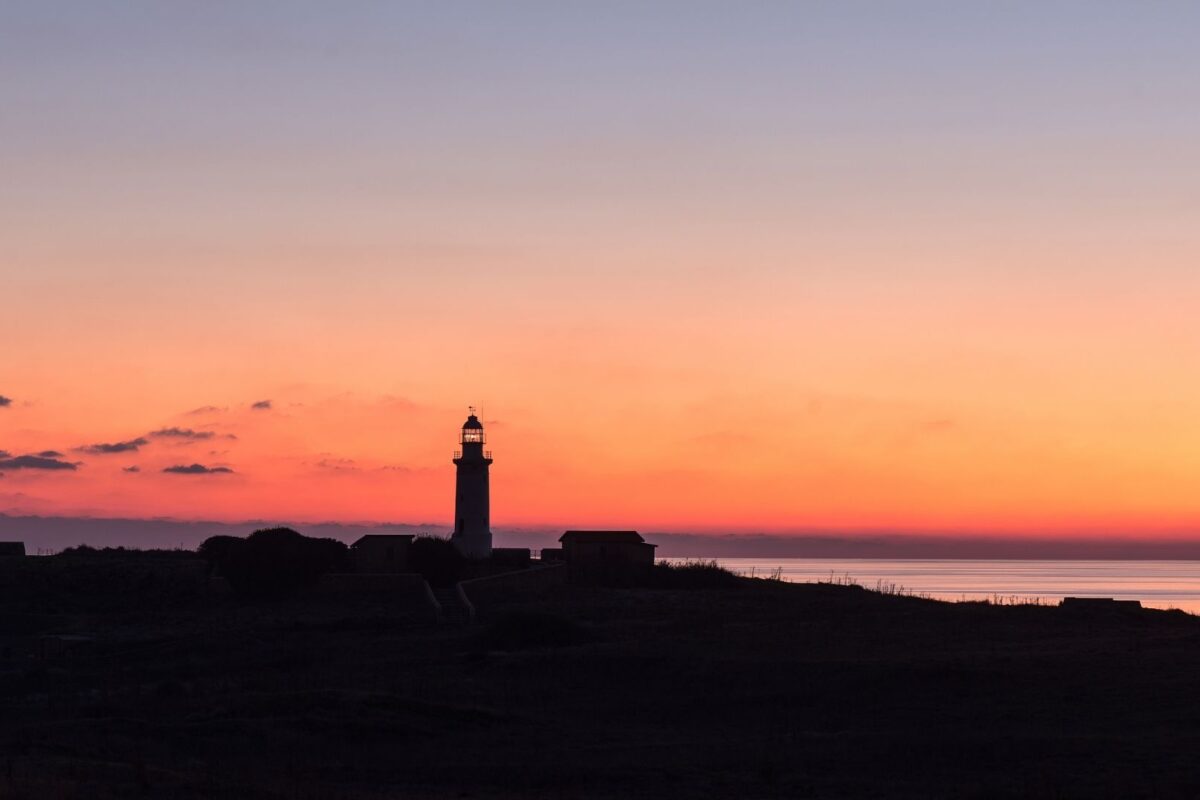 Imagen de un faro en la costa al atardecer.